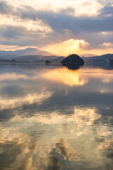 夕陽に照らされた湖面と静かな山々