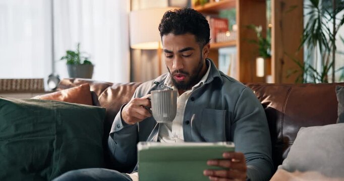 Happy man, tablet and watching with coffee on sofa for online entertainment or streaming in home. Male person, relax and drinking with technology for movie show, series or app subscription in house