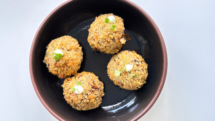 top flat view of bitterballen snacks in a bowl on a white background