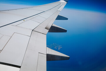 Plane flies over the blue Mediterranean Sea, a sunny summer day