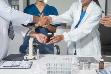 A handshake between scientists, researchers, or medical professionals signifies a successful...
