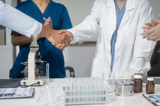 A handshake between scientists, researchers, or medical professionals signifies a successful agreement, marking the start of collaboration, partnership, or joint development in healthcare, science