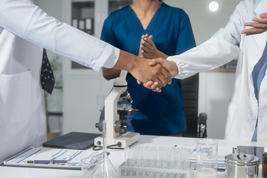A handshake between scientists, researchers, or medical professionals signifies a successful agreement, marking the start of collaboration, partnership, or joint development in healthcare, science