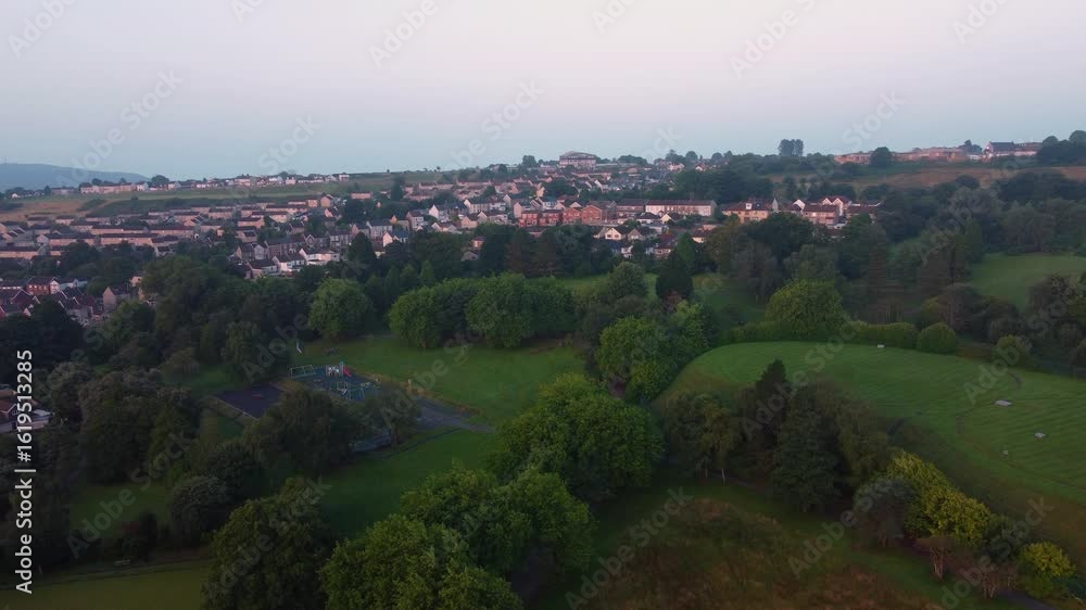 Poster aerial view of recreational park with empty playground and rows of suburban houses on hillside at su