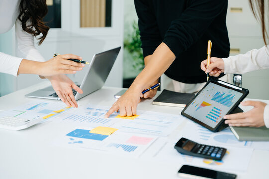 Business documents on office table with smart phone and calculator digital tablet and graph business with social network diagram and two colleagues discussing data working in the office