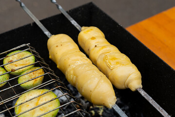 Chopped zucchini and khachapuri roasting on fire seasoned with aroma herbs and spices. Delicious...
