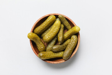 Wooden bowl with tasty pickled cucumbers on grey background