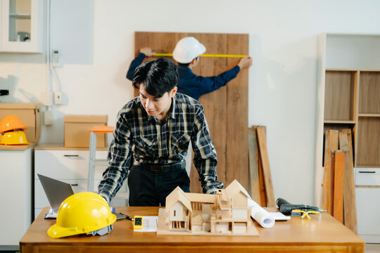 Architects and engineers collaborate on a building model, designing, planning, and measuring with teamwork,