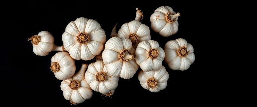 A cluster of fresh garlic bulbs, top-down view, against a black background,  food,  cooking