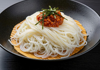 Chilled Japanese Somen Noodles with Savory Spicy Meat Sauce Topping and Green Nori in Black Bowl