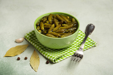 Bowl with tasty pickled cucumbers and different spices on grunge background, closeup