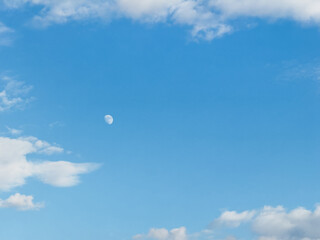 The moon is shining brightly in the sky, casting a silvery glow over the blue expanse. It is...