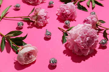 Beautiful peony flowers and disco balls on pink background