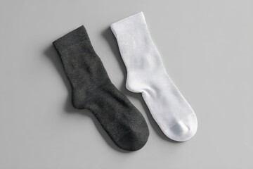 Two plain socks, dark gray and white, laid flat