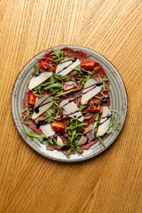 Carpaccio salad with arugula cherry tomato and parmesan cheese, top view