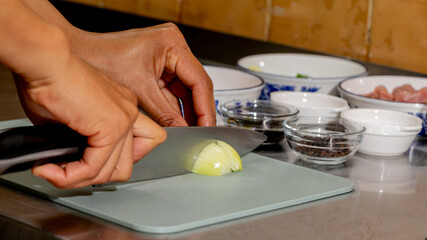 Cutting onions with precision, a Latinx woman conjures culinary magic, embracing Dia de los Muertos...