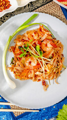 Vibrant shrimp pad Thai dances atop ceramic plate, merging Lunar New Year zest with Songkran's burst of fresh beginnings