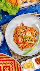 Shrimp pad thai radiates vibrant culinary artistry on Songkran's eve, enfolded by textures of woven...