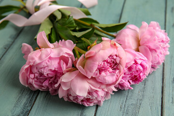 Bouquet of beautiful pink peony flowers on green wooden background, closeup