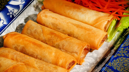 Golden spring rolls on ornate platter evoke Lunar New Year indulgence, crispy harmony, culinary delight, savory celebration