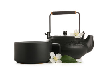 Cup and teapot of hot jasmine tea with flowers on white background