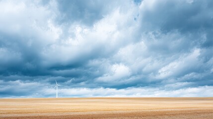 Expansive landscape featuring a wind turbine on a golden field under dramatic clouds, showcasing renewable energy and nature's beauty