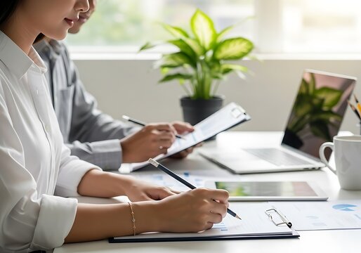 Business professionals analyzing data and making notes in a modern office setting - Powered by Adobe