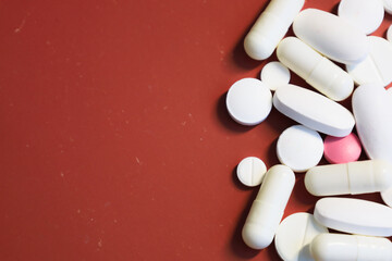 Part of the frame is filled with white pills and capsules of various shapes, along with one pink...