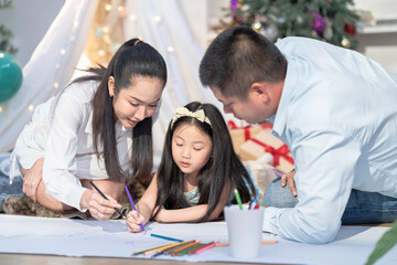 Together, love, education, childhood, holiday, parenting, joyful family spending creative time with daughter making coloring art on the floor, festive family holiday moment, Asian Seasonal celebration