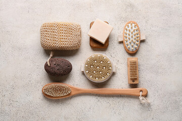 Composition with different massage body brushes, pumice stone and soap bar on white grunge...