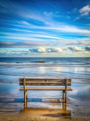 Serene ocean views from a weathered wooden bench at low tide