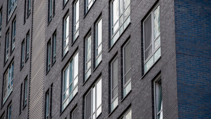 empty glass windows of a modern building with a reflection of the sky in the glass