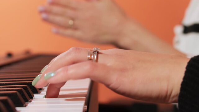 Teacher clapping serves as guide for student playing piano. Instructor rhythmic encouragement helps woman internalize beat slow motion