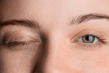 Winking woman with beautiful green eyes, closeup