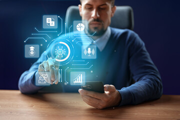 Innovative technology concept with man using smartphone and holographic display in modern office environment