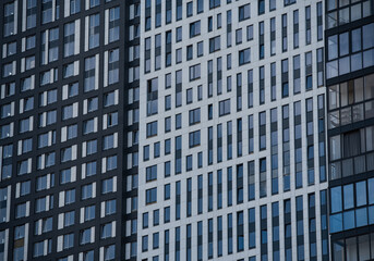empty glass windows of a modern building with a reflection of the sky in the glass