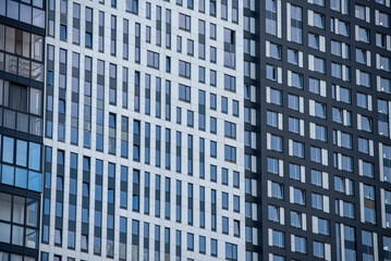 empty glass windows of a modern building with a reflection of the sky in the glass