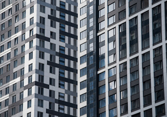 empty glass windows of a modern building with a reflection of the sky in the glass