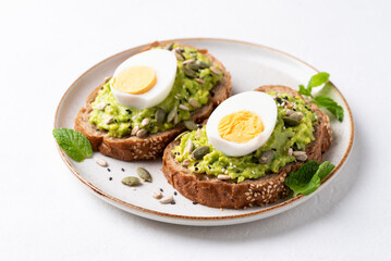 Avocado toast with boiled egg, sunflower seeds, pumpkin seeds and sesame seeds on plate, Healthy eating