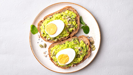Avocado toast with boiled egg, sunflower seeds, pumpkin seeds and sesame seeds on plate, Healthy eating