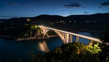 Obraz premium Illuminated bridge over a serene lake at twilight