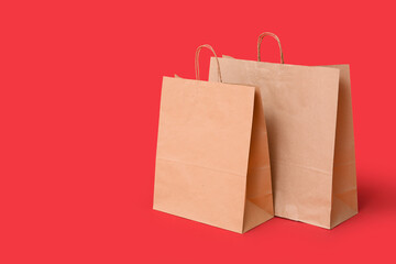 Paper shopping bags on red background
