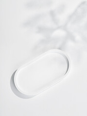 empty isolated white clean simple plaster tray and oval ceramic base stand with tree shadow and shade silhouette on desktop tabletop display background
