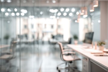 Blurred view of a modern, bright office space with desks, chairs, and glass partitions