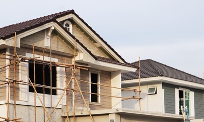 Housing renovation project with new paint and bamboo scaffolding show exterior facade of roof and wall. Image use for construction industry presentation background.