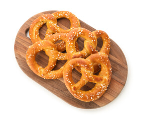 Wooden board with tasty salted pretzels on white background