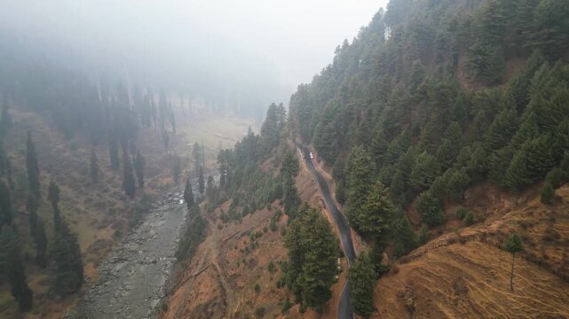 Pahalgam valley with fog over autumn trees and mountains