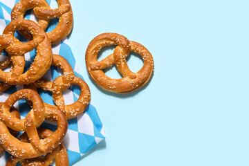 Tasty salted pretzels with flag of Bavaria on blue background