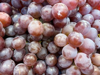 Close up showcases a heap of red grapes creating a vibrant and textured scene