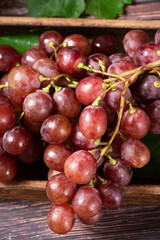 sweet red grapes on wooden table.
